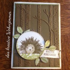 a card with a hedgehog on it's front and leaves around the edges