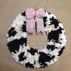 a black and white wreath with pink bows