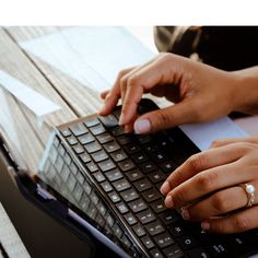 a person typing on a laptop computer with their hands resting on top of the keyboard