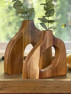 two wooden vases with plants in them on a table