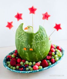 a watermelon sculpture made to look like a bird sitting on top of berries