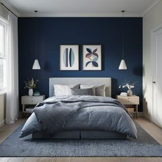 a bedroom with blue walls and white bedding, two framed pictures on the wall