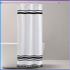 a white shower curtain with black and white stripes on the bottom is in front of a bathtub