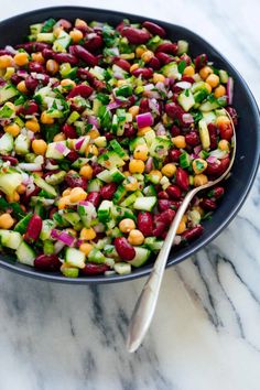 a bowl filled with beans, cucumbers and other vegetables