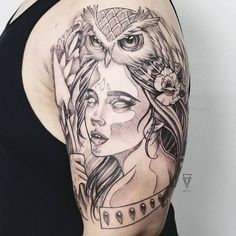 a woman with an owl tattoo on her arm and shoulder, holding a flower in her hand