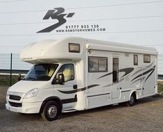 a white motor home parked in front of a building