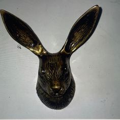 a brass colored rabbit head on a white surface with the word,'i love you'written below it