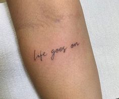 a person with a tattoo on their arm that says life goes on in cursive writing