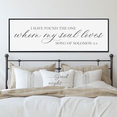 a bedroom with a bed, pillows and a framed sign above it that says i have found the one whom my soul loves song of solomon