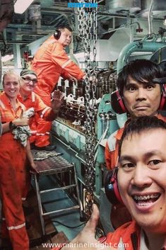 some people in orange suits and headphones on a ship with other people around them