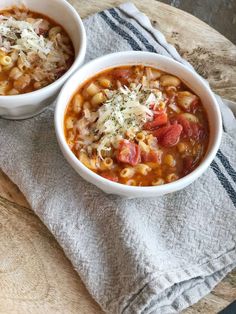 two bowls of pasta soup on a wooden table