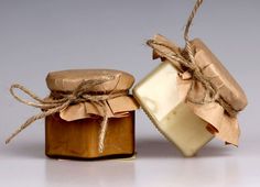 a jar of soap next to a piece of wax on a white surface with twine