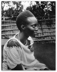 a black and white photo of a woman sitting on a bench