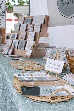 many cards are on display at an outdoor market with wicker baskets and paper towels