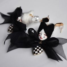 two black and white dolls are sitting next to each other on a table, one is holding a key chain