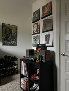 there are many pictures on the wall above the bookshelf