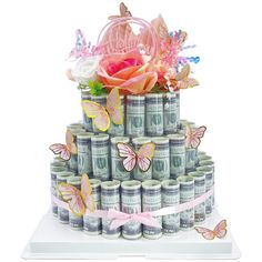 a cake made out of stacks of money with pink flowers and butterflies on the top