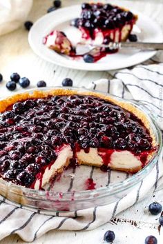 a blueberry cheesecake on a plate with a slice cut out and ready to be eaten