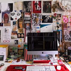 an apple computer sitting on top of a desk covered in pictures and photos, next to a keyboard