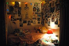 a bedroom with many pictures on the wall and a bed in front of it at night