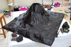 there is a very large piece of chocolate cake that looks like a volcano on the table