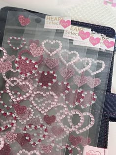 heart shaped sequins are displayed on a piece of fabric with pink and red accents