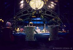 a group of people sitting at a table in front of a large chandelier