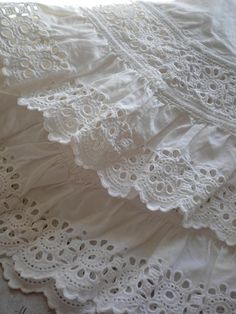 white lace is laying on top of a bed