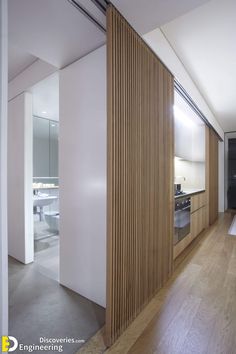 an empty kitchen and living room with wood paneling