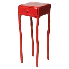 a small red table with one drawer on it