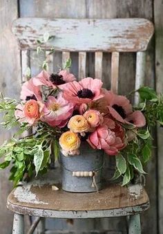 a bucket filled with lots of flowers sitting on top of a chair