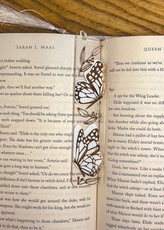 an open book with some butterflies on it