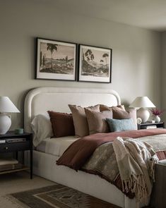 a bedroom with two pictures above the bed