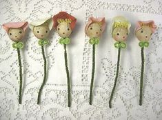 five little doll heads are placed on top of each other in the shape of flowers