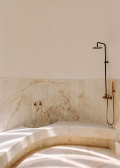 a bathtub in the corner of a bathroom with a shower head and hand held faucet