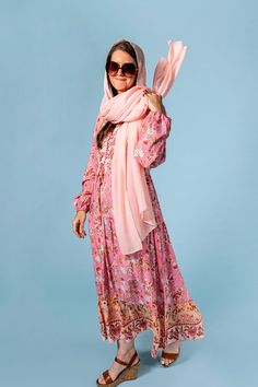 a woman wearing a pink scarf and dress