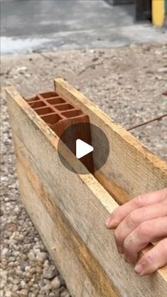 a person is placing bricks into a wooden box