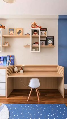 a child's bedroom with blue walls and white furniture, including a desk in the corner