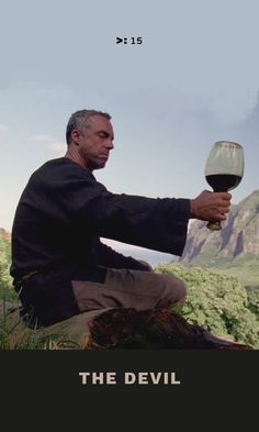 a man sitting on top of a tree stump holding a wine glass in his hand