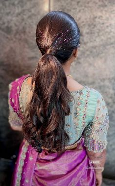 a woman with long hair wearing a pink sari and a headpiece in her hair