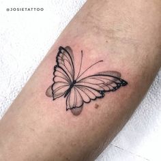 a black and white butterfly tattoo on the leg