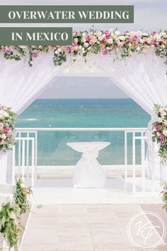 an overwater wedding in mexico with flowers and greenery on the altar, overlooking the ocean