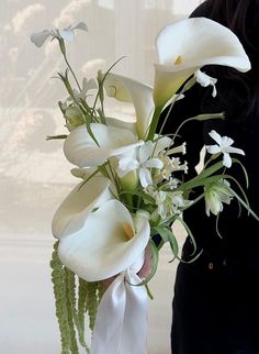 a woman holding a bouquet of white flowers