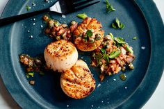 a blue plate topped with scallops and vegetables