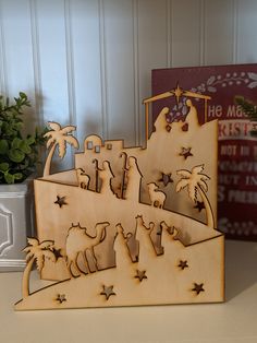 a wooden nativity scene is shown on a table