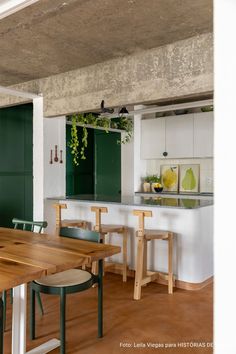 a kitchen with green cabinets and wooden tables