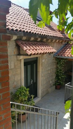 an outside view of a house with a gate and potted plants on the patio