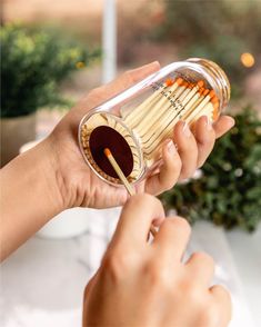 a person holding a glass container with chopsticks in it