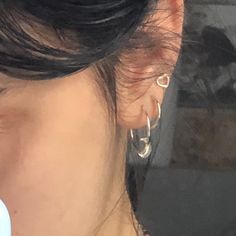 a close up of a person with ear piercings on their ears and wearing earrings