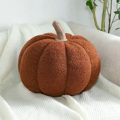 a brown pumpkin sitting on top of a white blanket